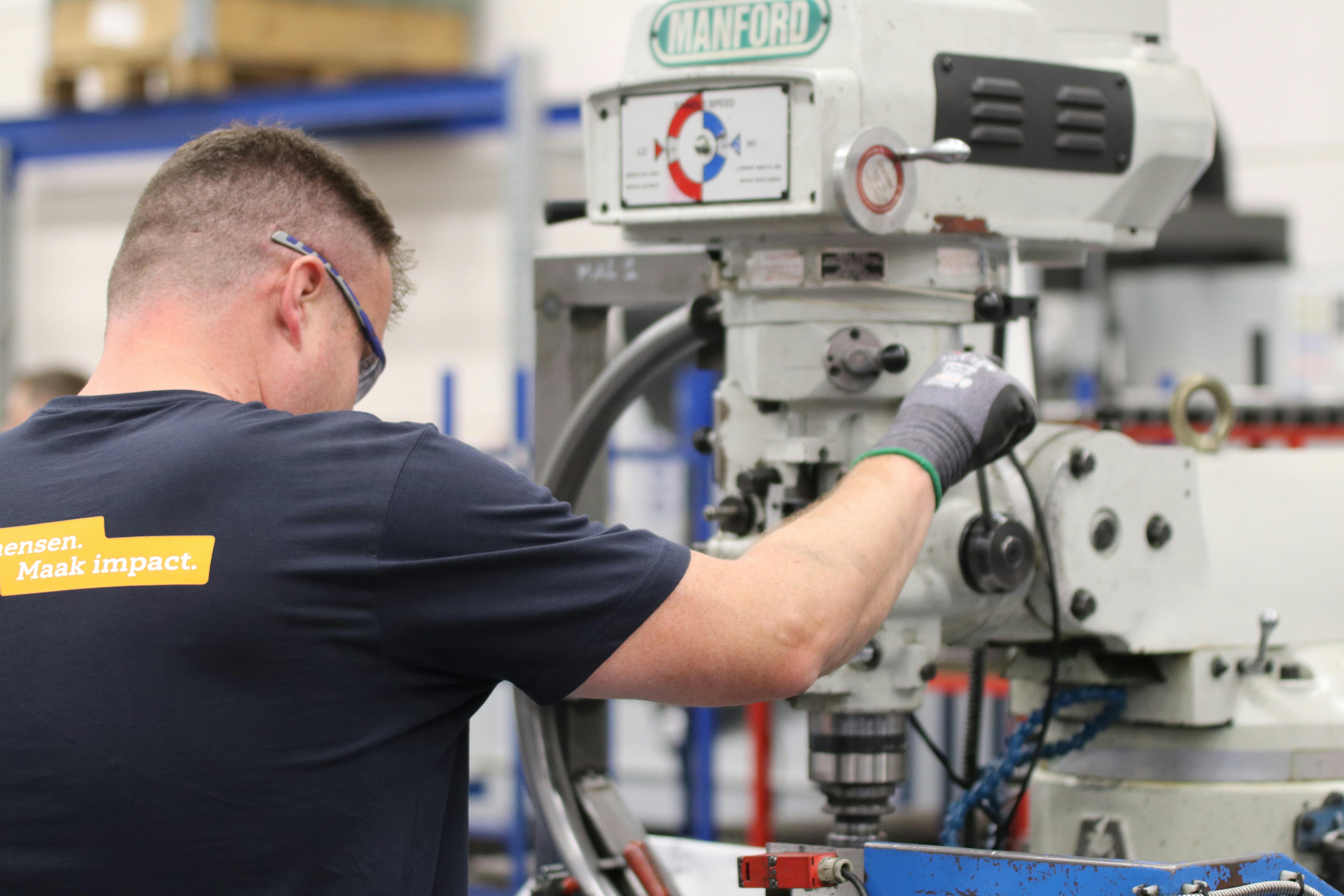 Machinist operating milling machine in precision manufacturing shop