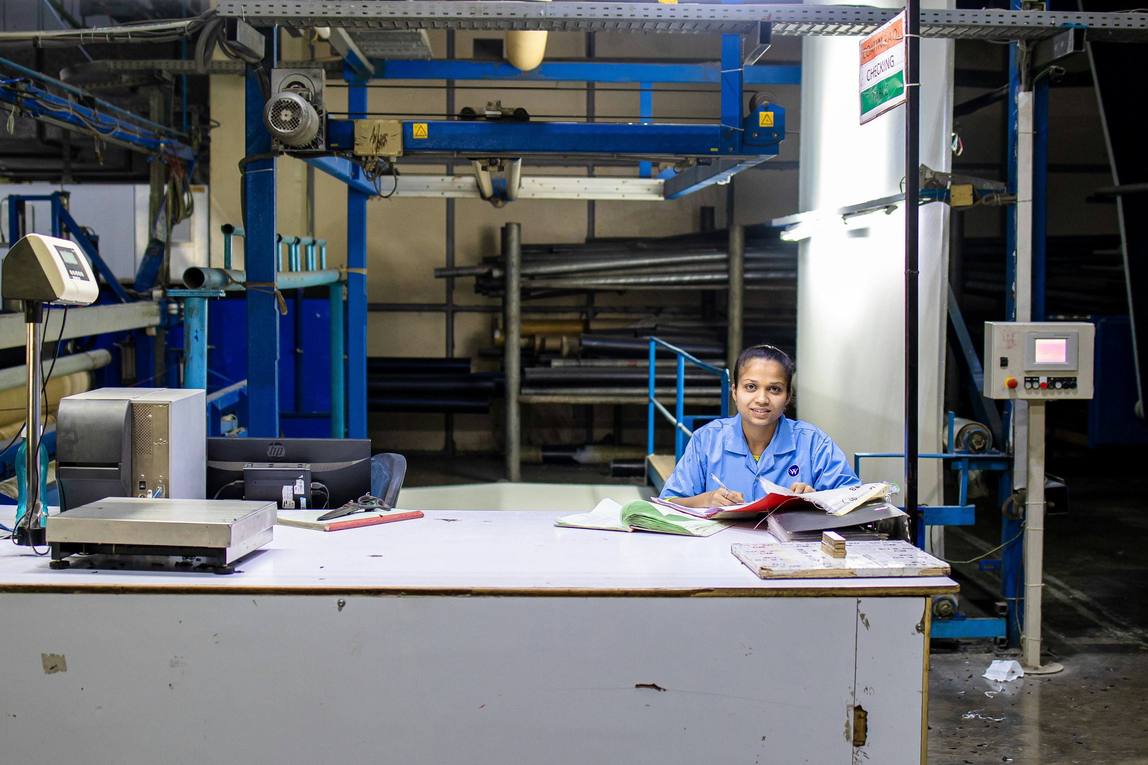 Factory worker surrounded by paperwork and invoicing documents at a desk